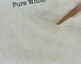 May include: A close-up of a white glitter, with the text "Pure White" written above it.