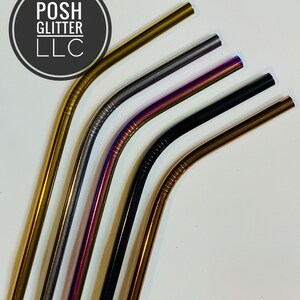 May include: Five reusable metal drinking straws in different colors: gold, silver, purple, black, and copper. The straws are bent at the top and are arranged in a fan shape.