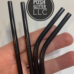 May include: Four black metal reusable drinking straws. The straws are bent at the top and have a textured surface.