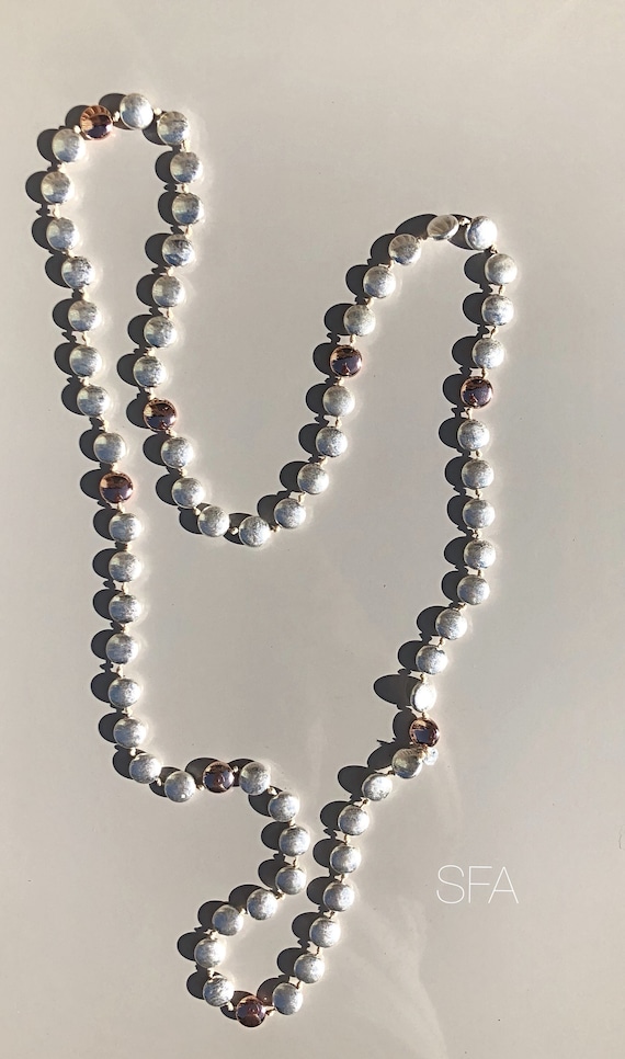 Long beaded tarnished necklace, with rose gold and tarnished silver beads on white thread.