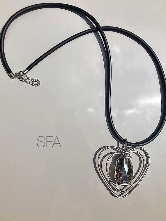 Lagenlook thick black rubber necklace. With twisted wire heart with large glass crystal in smokey grey.