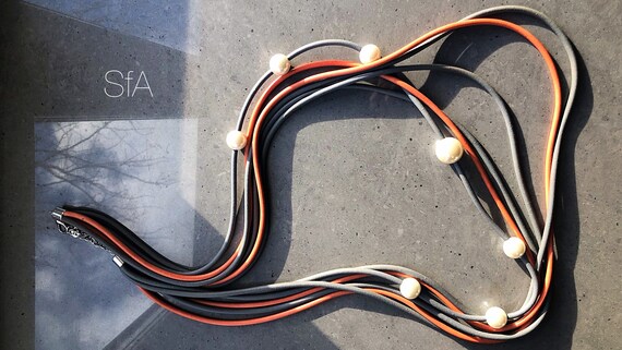 Rubber necklace, multi thread, with pearls. In mid orange and grey.