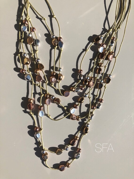 Multi strand beaded necklce on twine, with lobster clasp with extension chain