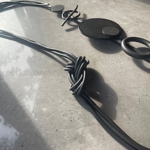 Black Rubber necklace, with multiple sizes of wooden black discs, lightweight.