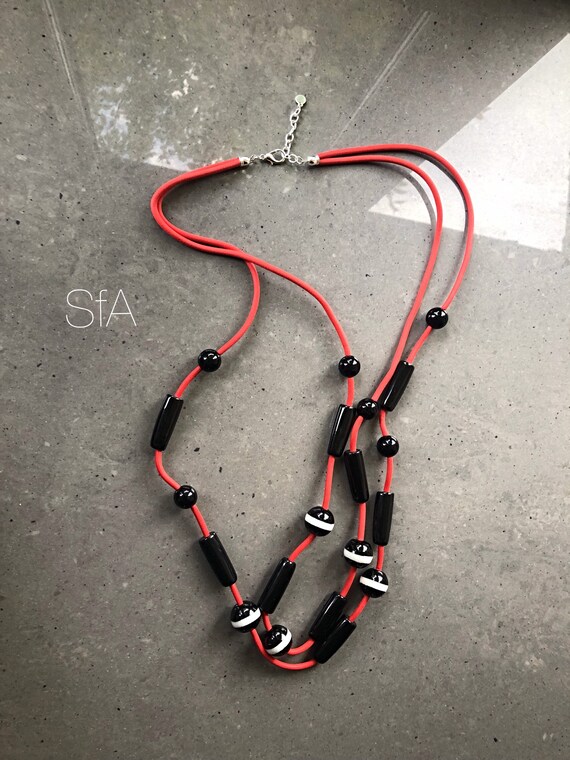 Lagenlook rubber necklace, long multi thread, in red double rubber thread with black and black and white glass beads.