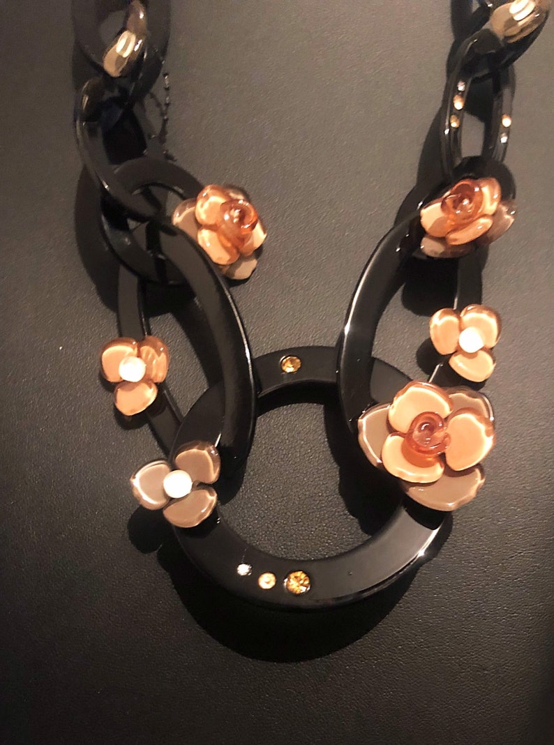 The Leila acrylic black and taupe flower acrylic circular necklace with ribbed ribbon tie