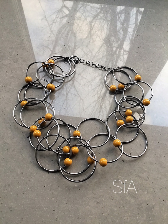 Geo metric necklace, lagenlook necklace, in gunmetal tone. With interlinked rings, and mustard beads.