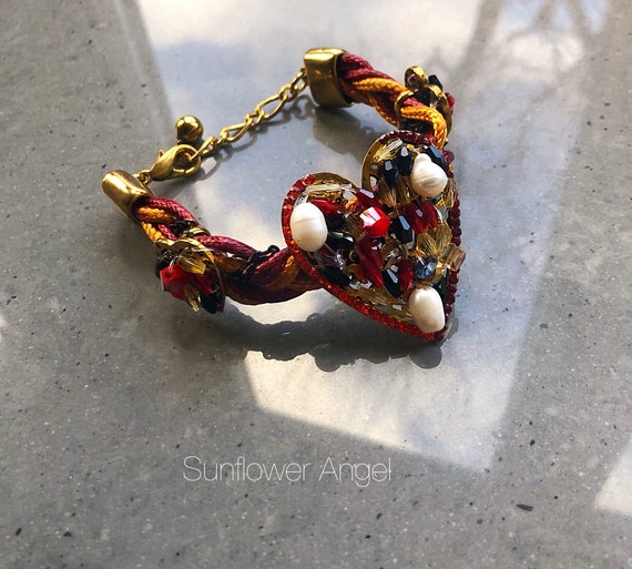 Woven plaited bracelet, with gold hearts adorned with beads and water pearls.