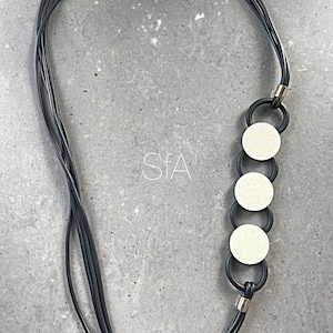 Multi strand black rubber necklace, with cream wooden round discs