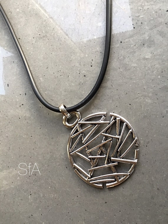 Lagenlook abstract necklace, with large round pendant, on a thick rubber thread.