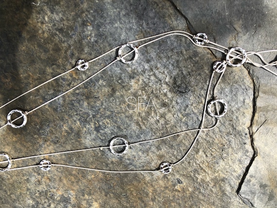 Long silver tone, geo necklace with double chain, perfect for all outfits.