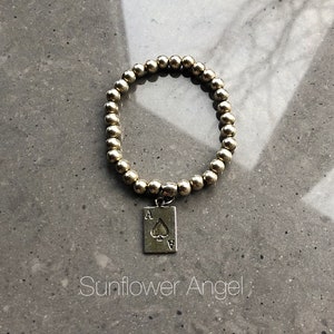 Bracelet as de cartes à jouer en métal argenté, monté sur élastique, taille unique.