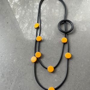 Black multi thread rubber necklace, with wooden round shapes.