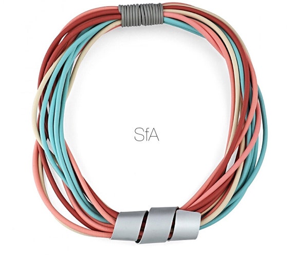 Multi strand rubber spaghetti necklace, rainbow shades with frosted twisted metal pendant.