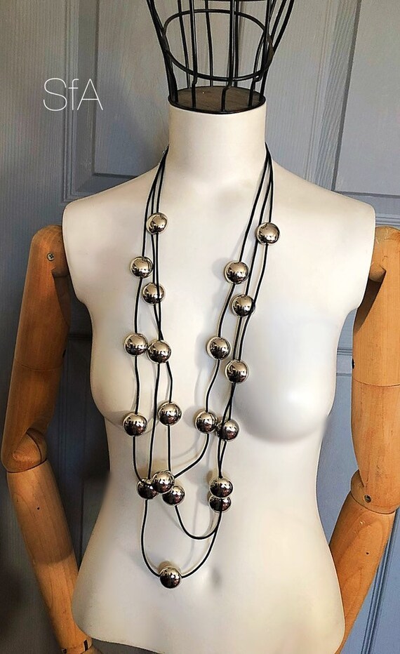 Funky Lagenlook necklace with silver polished pebbles and black or grey leather thread .