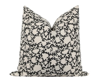 May include: A black and white patterned throw pillow with a floral design. The pillow is made of a soft, linen fabric.