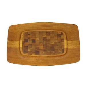 May include: Wooden chopping board, rectangular with a light brown frame and a central area of small, square, mosaic-style wood pieces. The board has a smooth, natural finish, suitable for food preparation.