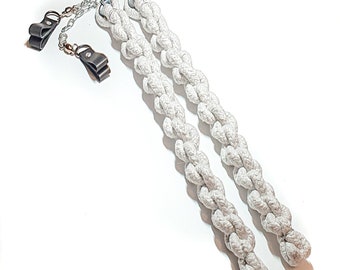 May include: A pair of white rope poi with silver chain and black leather handles. The poi are braided and have a twisted rope design.