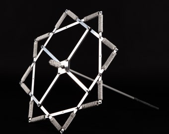 May include: A silver metal fire poi with eight spokes and white rope wrapped around each spoke. The poi is attached to a long silver metal handle.