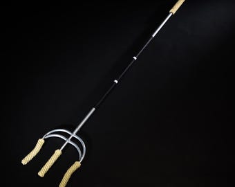 May include: A black and silver three-pronged staff with beige rope handles. The staff is made of metal and has a black grip.
