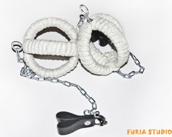 May include: Two white rope rings with a silver chain and black clips. The rings are connected to the chain and the clips are attached to the chain.