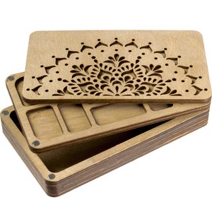 Puede incluir: Una caja de madera con una tapa con bisagras que presenta un dise&ntilde;o de mandala cortado con l&aacute;ser. La caja tiene varios compartimentos en el interior.
