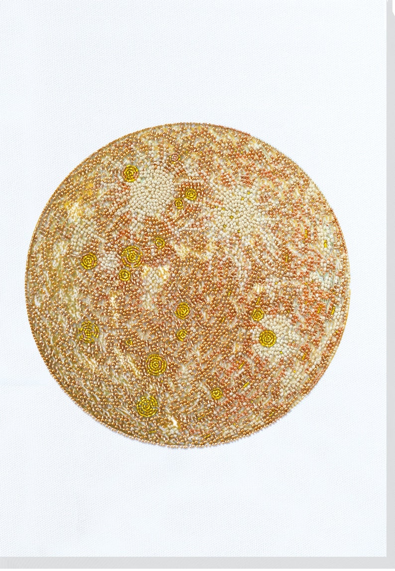 May include: A close-up of a circular beaded artwork depicting a planet with a textured surface. The artwork is made with small, white, gold, and orange beads.