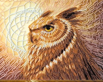 May include: Close-up of a beaded owl with brown, gold, and white beads. The owl's eye is a bright yellow bead. The background is a light brown with a beaded design.