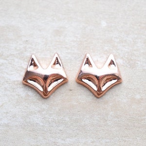 May include: A pair of rose gold fox head stud earrings. The earrings are small and delicate, and they would make a great gift for anyone who loves foxes.
