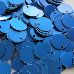 May include: A large pile of blue metal circles with a small hole in the centre of each circle.