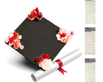 May include: A black graduation cap decorated with pink and red flowers, a white diploma scroll tied with a red ribbon, and two sheets of gold glitter alphabet and number stickers.