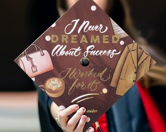 May include: A graduation cap with the text "I Never Dreamed About Success, I Worked for It." The cap is brown with gold glitter accents and illustrations of a purse, coffee cup, and a coat.