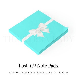 May include: A stack of turquoise Post-it® note pads with a white ribbon and bow. The text "THE ZEBRA LADY" and "Post-it® Note Pads" are displayed above and below the pads, respectively. The website address is also visible.