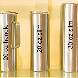 May include: Three stainless steel tumblers with lids. The tumblers are labeled 20 oz handle, 20 oz slim, and 30 oz slim.