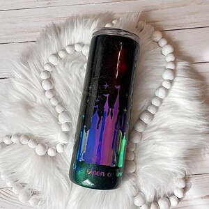 May include: A black and green tumbler with a holographic iridescent finish. The tumbler features a silhouette of a castle with stars and the text "Once Upon a Time".