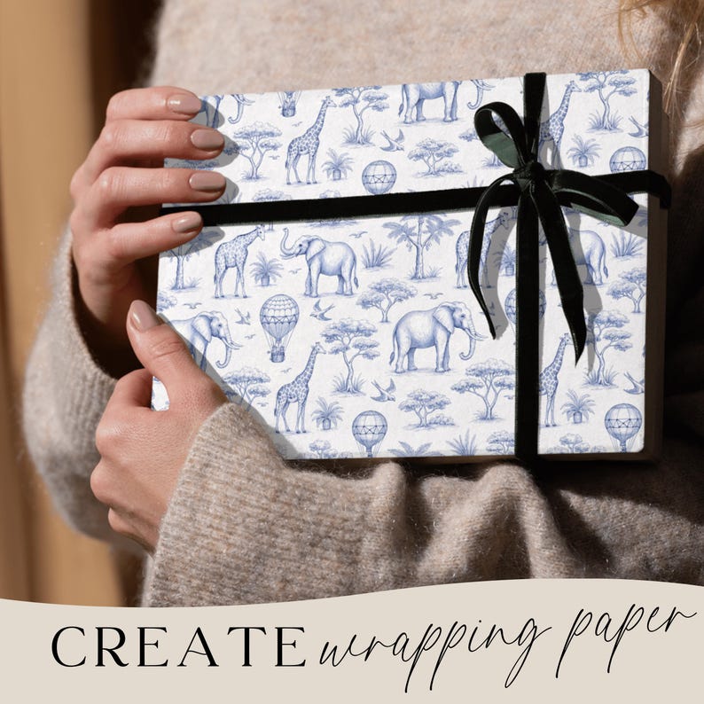 May include: A wrapped gift box featuring a blue and white safari animal pattern, including elephants, giraffes, and hot air balloons. The box is tied with a black ribbon. The words "CREATE wrapping paper" are at the bottom.