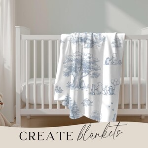 May include: White baby blanket with a blue illustrated forest scene featuring animals and trees. The blanket is draped over a white crib. The words "CREATE blankets" are written in black script at the bottom of the image.
