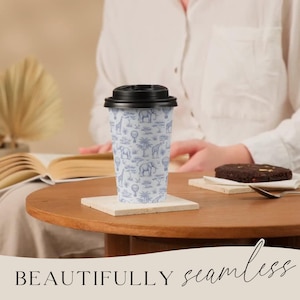 May include: A white travel mug with a black lid, featuring a blue safari animal pattern. The mug is on a square coaster, with a brownie and a spoon nearby. The text "BEAUTIFULLY seamless" is at the bottom.