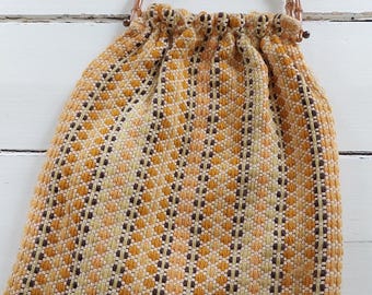 Bolso vintage tejido con asa de bambú, estilo bohemio de los años 70 en amarillo mostaza y marrón, con textura retro, hecho a mano en estilo escandinavo.