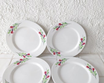 May include: Set of four white ceramic dinner plates with a floral design. Each plate features a green stem with pink and purple flowers.
