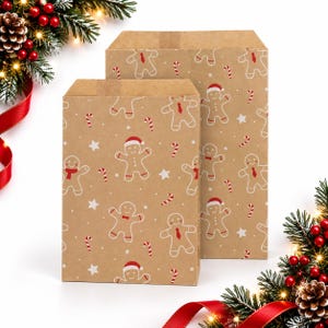 May include: Two rectangular brown paper bags featuring a repeating pattern of white gingerbread people, red and white candy canes, and white stars. The gingerbread figures are decorated with red hats, scarves, or ties, set against a plain background.