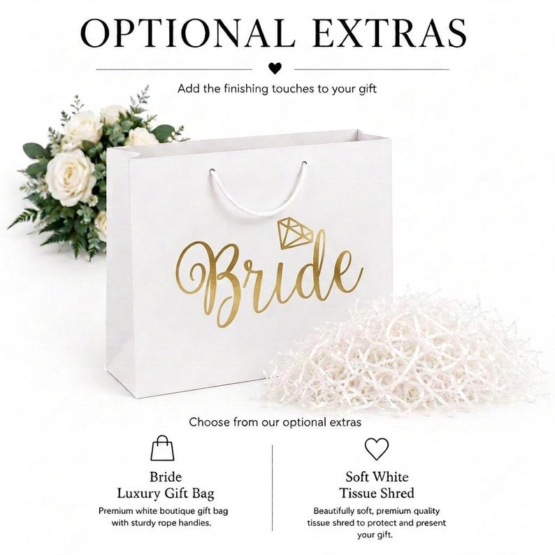 May include: A white gift bag with gold foil text reading Bride and a diamond icon, featuring white rope handles. Beside it is a pile of white tissue paper shred. Text at the top reads OPTIONAL EXTRAS and Add the finishing touches to your gift.