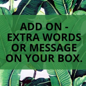 Può includere: Un banner verde con il testo "ADD ON - EXTRA WORDS OR MESSAGE ON YOUR BOX." su uno sfondo di foglie tropicali verdi e bianche. Il testo è in grassetto, in nero.