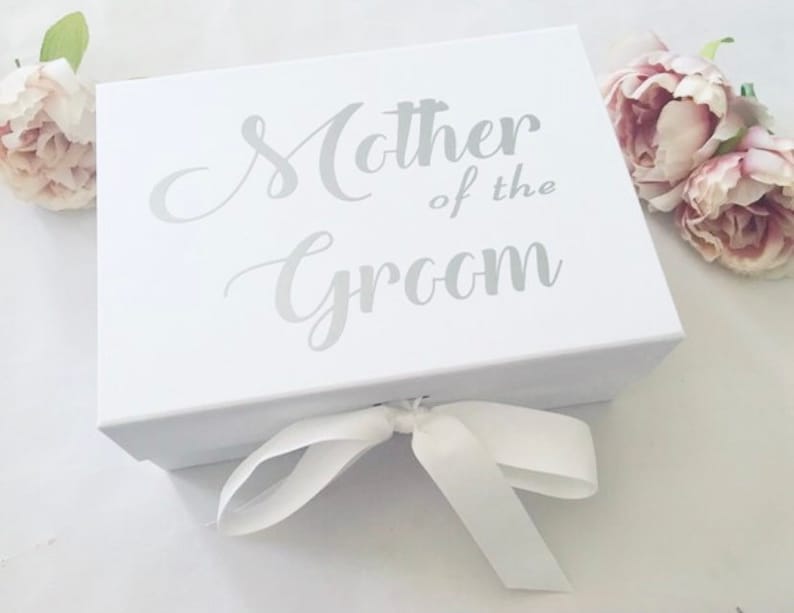 May include: White gift box with a silver ribbon and the text "Mother of the Groom" printed on the top.