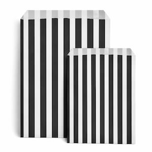 May include: Two rectangular paper bags featuring a vertical striped pattern in black and white. The bags are positioned with one slightly behind the other, both displaying a consistent monochromatic design with clean, straight lines throughout the surface.
