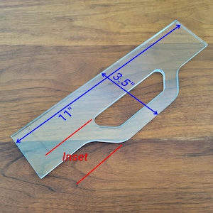 May include: A clear plastic template for making an inset, measuring 11 inches long and 3.5 inches wide. The template has a cutout for a handle.