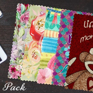 May include: A 5 pack of fabric squares with various designs. One square features a watercolor floral pattern with pink, red, and yellow flowers. Another square has a colorful striped pattern with blue, yellow, and green stripes. A third square has a teal and purple glitter mermaid scale pattern. The final square has a red background with a brown monkey wearing a red heart and the text "life's a monkey business".