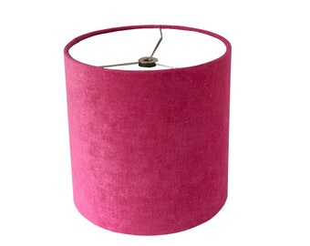 May include: A pink velvet lampshade with a white interior.
