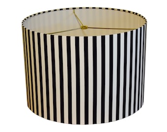 May include: A black and white striped lampshade with a gold metal frame.