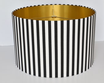 May include: A black and white striped lampshade with a gold interior. The lampshade is cylindrical and has a diameter of approximately 16 inches.